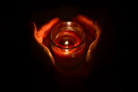 Hands guarding a candlelight Stock Photos