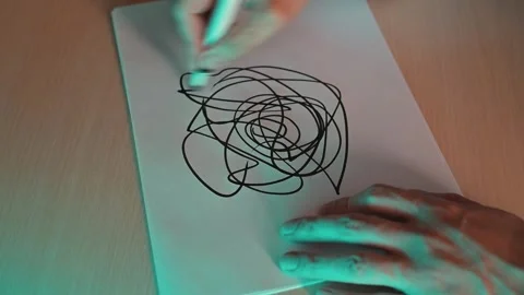 Hands guide a black marker across white paper, creating a series of abstract Vidéo 337558834