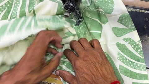 Hands guiding cloth through sewing machine in tailoring workshop Stock Footage 331796281
