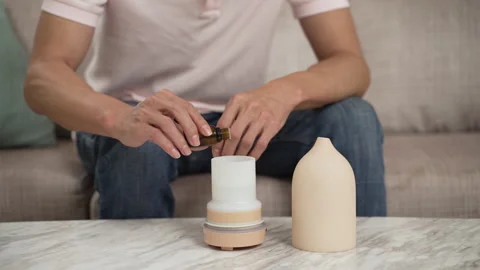 Hands of guy putting essential oil into diffuser Stock Footage 251432192
