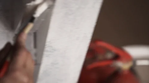 Hands of guy worker professionally paint grey walls in white with wooden brush Stock Footage 99274204