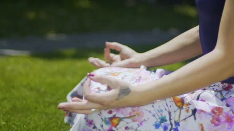 Hands in gyan mudra rack focus, woman sits in park and meditates, proper pose Stock Footage 96718996