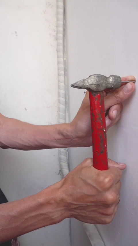 Hands hammer a nail into the wall with a hammer. Stock Footage 320574193