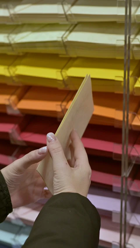 Hands Handling Colorful Paper Sheets in a Home Decor Store Vídeo Stock 345409013