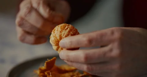 Hands handling a small piece of food over a plate in soft indoor light Vidéo 336136342