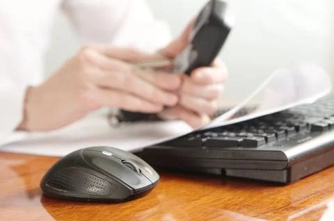 Hands with handset on a computer keyboard Stock Photos