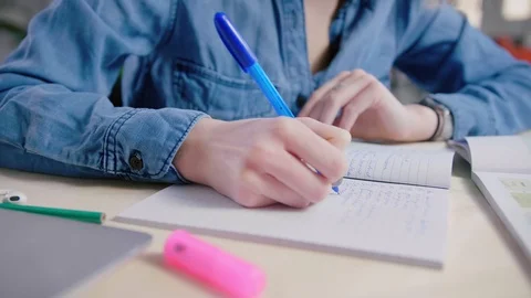 Hands handwriting on notebook at table Doing homework exercises and studying Stock Footage 103285287