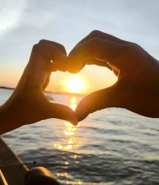 Hands in heart shape at sunset Stock Photos