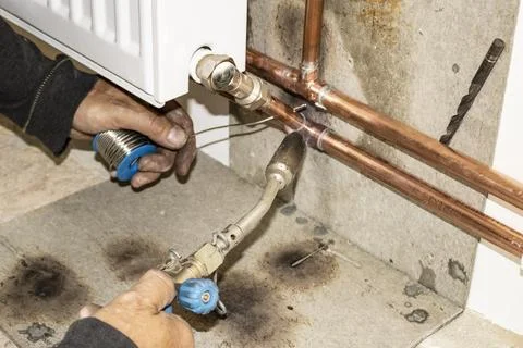 Hands of a heating engineer, welding copper heating pipes Stock Photos
