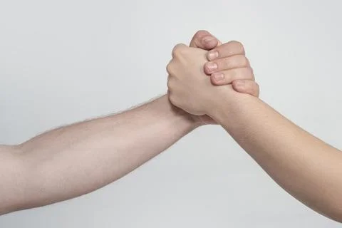 Hands helping with physical touch. Hands help through forearm holding. Hand.. Stock Photos