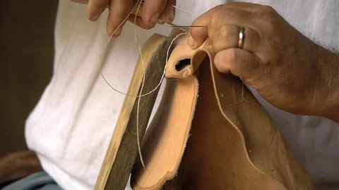 Hands - in historical setting, sews leather with needle and thread - mending Stock Footage 81242378