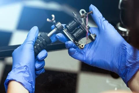 Hands hold a blue tattoo machine Foto stock