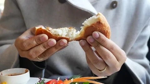 Hands hold bread bun at local cafe in morning Stock Footage 333224874