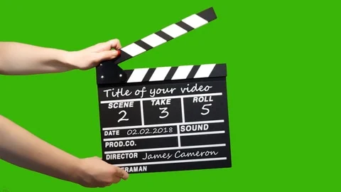 Hands hold clapperboard on the green screen. Insert your text on clapper board Stock After Effects