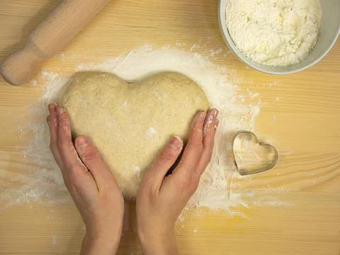 Hands hold dough in heart shape. Valentines day. Heart shaped food Stock Photos