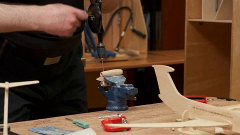 Hands hold drill and make holes in wooden jetliner detail 스톡 동영상 127374838