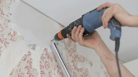 Hands hold electric drill in room, repair in apartment. Man is drilling a wall. Stock Footage 106526944