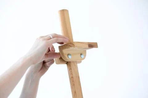 Hands hold an empty easel on a white background. Stock Photos