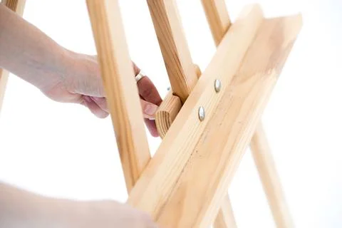 Hands hold an empty easel on a white background. Stock Photos