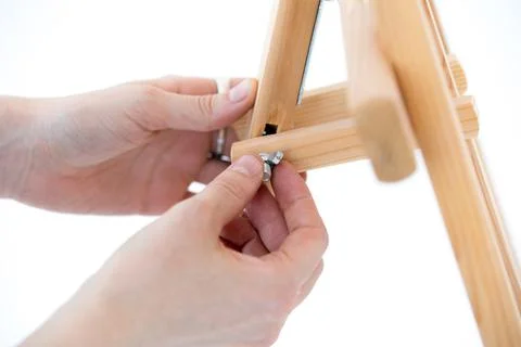 Hands hold an empty easel on a white background. Stock Photos