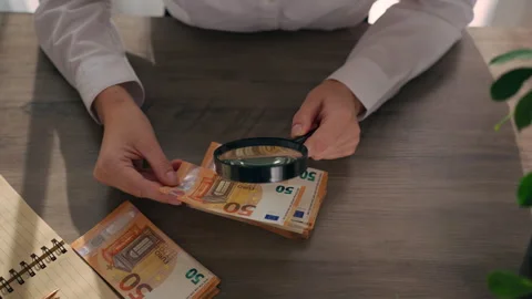 Hands hold euro banknotes and examining through magnifying glass, check aut.. Stock Footage 337178992