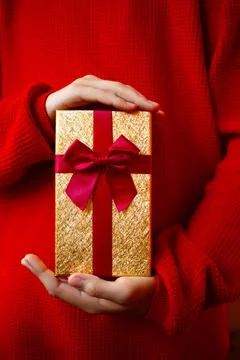 Hands hold a gift on a red background Stock Photos