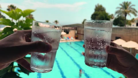 Hands hold glasses of cold, refreshing sparkling water. People clink glasses and Stock Footage 330132581
