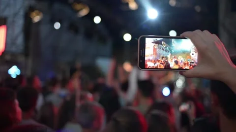Hands Hold Mobile Camera With Digital Display Among People During Rock Concert Stock Footage 68696943