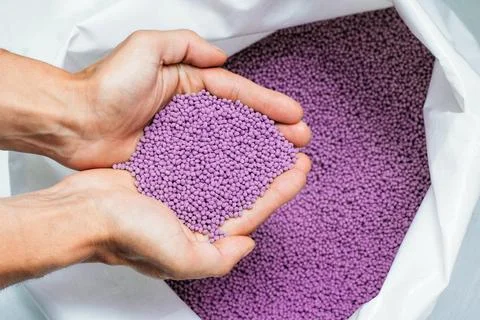 Hands hold or touching biodegradable plastic pellets, plastic polymer granules Stock Photos