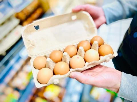 Hands hold a set of chicken eggs. Supermarket. Mobile photo. 스톡 사진