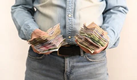 Hands hold several thick stacks of banknotes, highlighting volume of cash, 스톡 사진