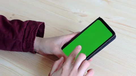 Hands hold a smartphone in an upright position with a green screen. Stock Footage 153858165