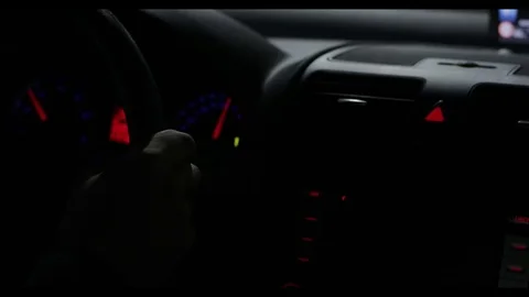 Hands hold steering wheel driving car at night dark tunnel close-up with panel Stock Footage 79641345