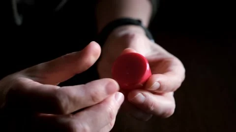 Hands hold two red magnets, illustrating their magnetic properties as they are Stock Footage 321862192