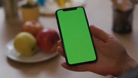 Hands hold use smartphone with vertical green screen on kitchen at home woman Stock Footage 105110075