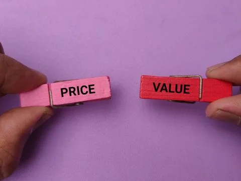 Hands hold wooden pegs labeled PRICE and VALUE against a purple background Stock Photos