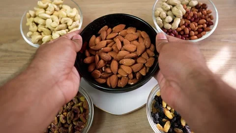 Hands Holding Almonds with Nut Assortment Stock Footage 318578516