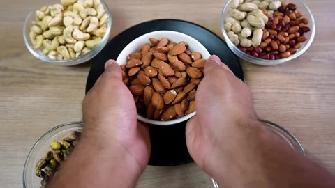 Hands Holding Almonds Surrounded by Nuts Stock Footage 320726887