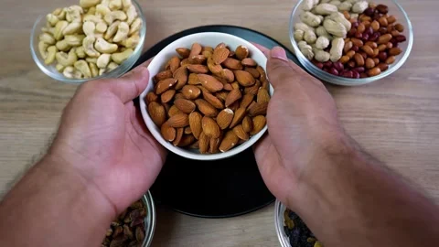 Hands Holding Almonds Surrounded by Nuts Stock Footage 320726900