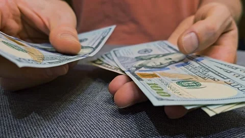 Hands holding and counting multiple US dollar banknotes Stock Footage 310851549