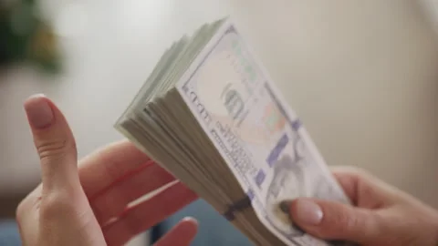 Hands holding and counting a stack of US dollar bills Stock Footage 277150863