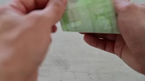 Hands holding and counting a stack of banknotes Stock Photos
