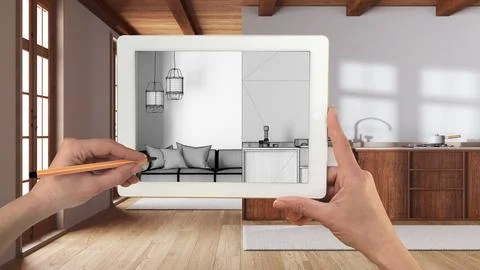 Hands holding and drawing on tablet showing kitchen and living room in boho.. Ilustración de archivo