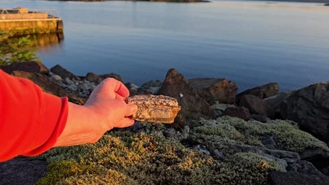 Hands Holding and Inspecting Smooth Pebbles Stock Footage 342847847