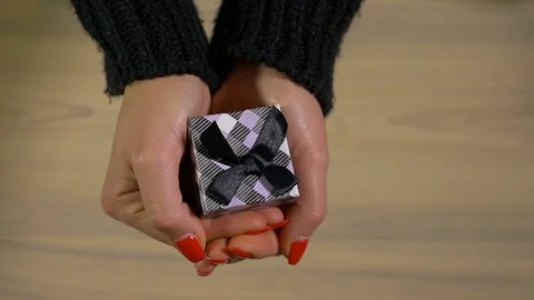 Hands holding and showing a small gift box Stock Footage 74133663