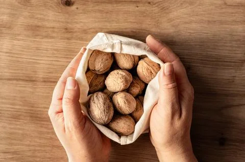 Hands holding bag of walnuts. Stock Photos
