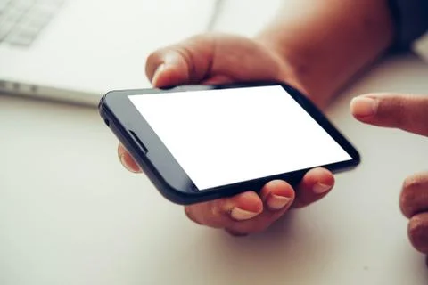 Hands holding blank screen mobile in desk work. Stock Photos
