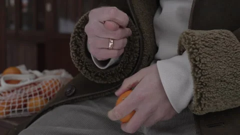 Hands Holding a Bright Orange Fruit in a Cozy, Relaxing Setting Vidéo 295410977