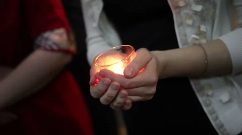Hands holding a burning candle Stock Footage 61766281