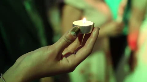 Hands holding a burning candle 스톡 동영상 65457528